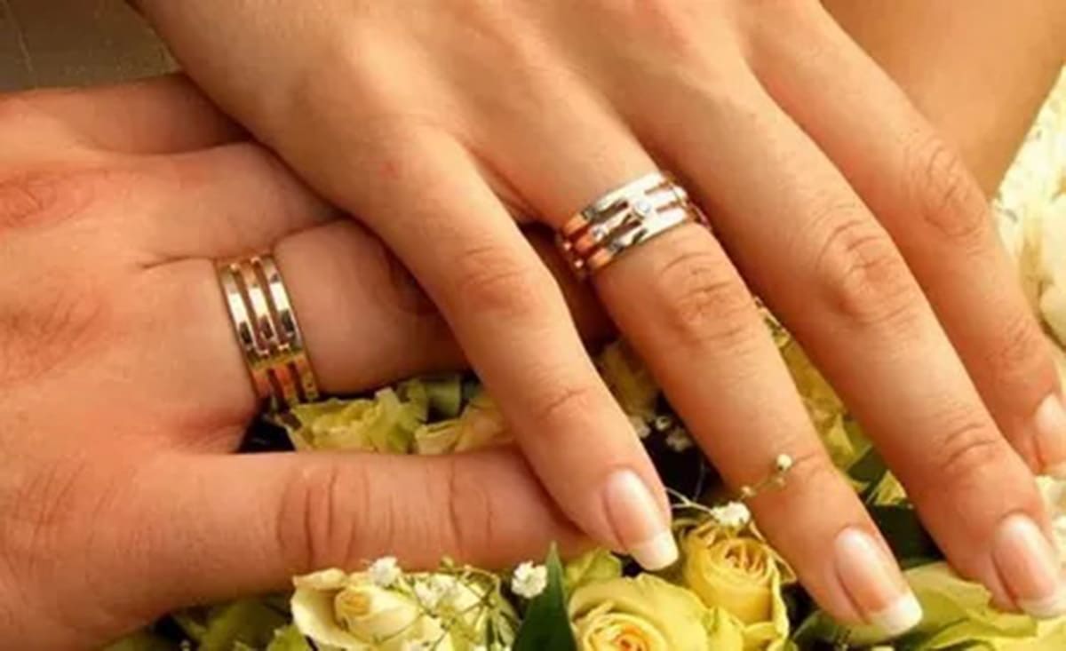 На какой руке носят кольцо брака. Обручальное кольцо на пальце. Обручальные кольца на руках. Свадебные кольца на пальцах. Широкое обручальное кольцо на руке.